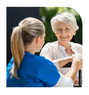 Caregiver assisting smiling senior woman during home care visit