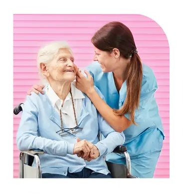 Caregiver holding hands with senior woman in wheelchair during home care visit